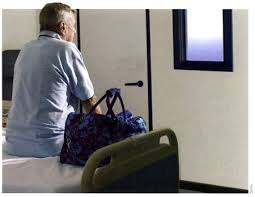 A patient sitting on their hospital bed with packed bags nearby, symbolizing a potential Discharge Against Medical Advice (DAMA) scenario.