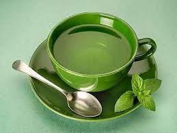 Close-up of a mug filled with freshly brewed green leaf tea.