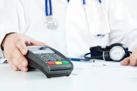 Doctor offering card machine for payment in office setting