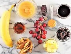 A close-up of various sugary foods such as fruit juice, candy, and glucose tablets, commonly used to raise blood sugar levels.